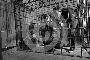 Black and white picture of victims imprisoned in a metal cage, g