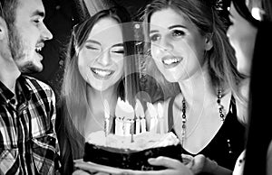 Black white pictures of happy friends birthday party candle cakes.