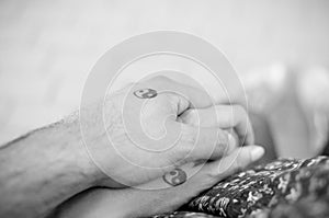 Black and white pictures. Two hands holding each other with yin and yang symbols.