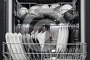 Black and white plates in an open dishwasher