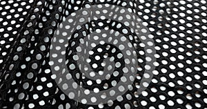 Black white polka dot fabric unrolled on tailor table