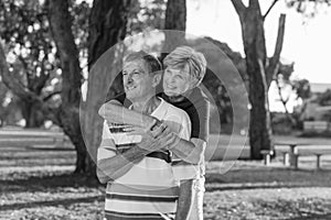 Black and white portrait of American senior beautiful and happy mature couple around 70 years old showing love and affection smili