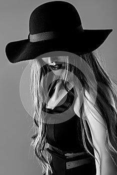 Black and white portrait of beautiful woman in black hat