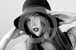 Black and white portrait of beautiful woman in black hat