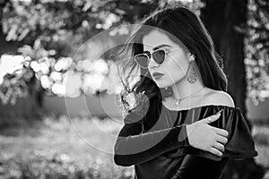 Black and white portrait of beautiful young brunette woman in a park