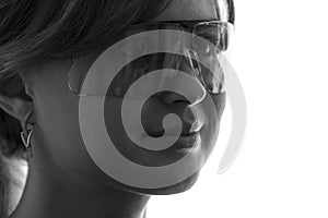 Black and white portrait of a beautiful young woman in protective glasses to work