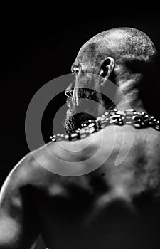 Black and white portrait of a brutal man tearing the chain