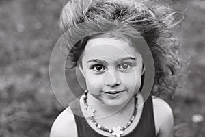 Black and white Portrait of cute little girl smiling outside