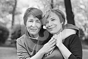 Black and white portrait of cute mature women 60s and 40s years in park