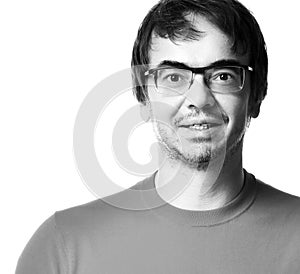 Black and white portrait of excited unshaved man in glasses and t-shirt over white background, close-up.