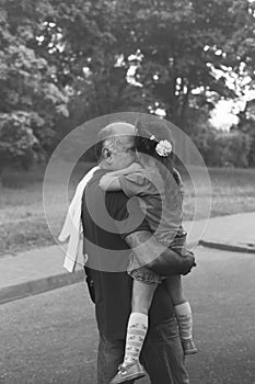 Black and white portrait of Happy granddad and grandaughter hugging at the park