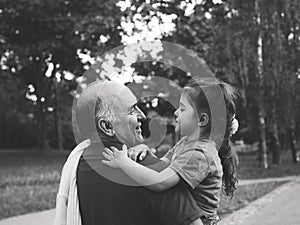 Black and white portrait of Happy grandfather and grandaughter playing at the park