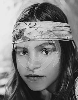 Black and white portrait of happy young woman wearing sixties style headband or scarf