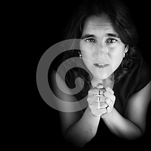 Black and white portrait of an hispanic woman praying