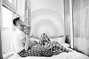 Black and white portrait of loving couple embracing in morning. Indoor shot of caucasian brunette man posing with wife