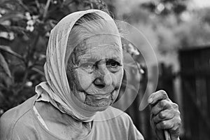 Black and white portrait of old lonly woman in headscarf. Elderly woman.