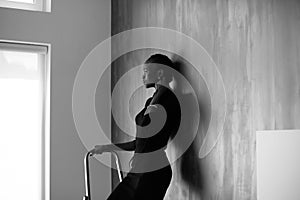 Black-and-white-portrait of pretty african or black american woman touching her thick plait on dark studio background