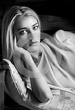 Black and white portrait of reclining feminine blonde woman