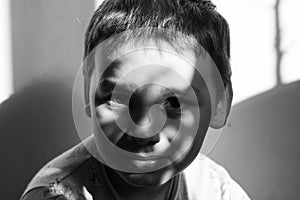 Black and white portrait of smiling baby boy in sunlight. Cute beautiful baby boy looking at the camera black and white