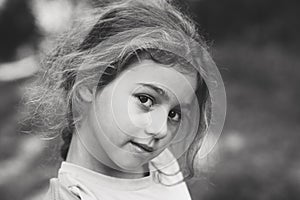 Black and white Portrait of smiling cute little girl at summer park. Happy child looking at the camera