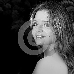 Black and white portrait of smiling girl that look at camera