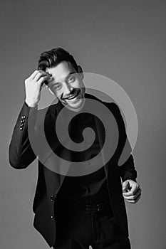 Black and white portrait of a smiling young handsome man in a suit