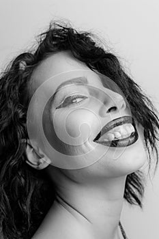 Black and white portrait of a smiling young woman with black lipstick