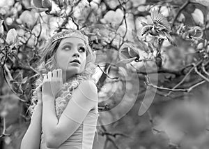 Black-white portrait of stunning young beauty blonde with jewelry for hair in the garden where magnolia trees bloom.  Jewelry for