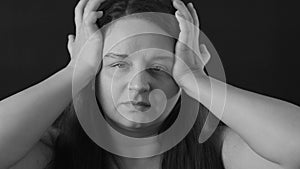 Black and white portrait of suffering exhausted middle-aged woman rub temples with hands, massaging, headache migraine.