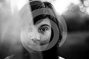 Black and white portrait of teen girl with expressive eyes, in the countryside