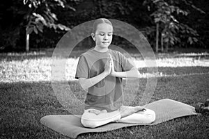 Black and white portrait of teen girl meditating at park
