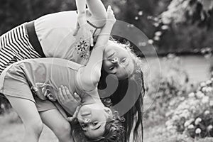 Black and white Portrait of Two Cute little girls embracing and laughing at garden. Happy kids outdoors