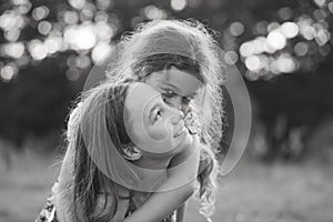 Black and white portrait of Two Happy little girls laughing and hugging at the  summer park