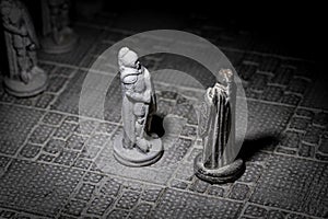 A black and white portrait of two soldier pieces of a game of chess facing each other in the beginning of the strategic duel. The