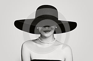 Black and white portrait of vintage woman in classic hat and pearls jewelry, retro styling girl
