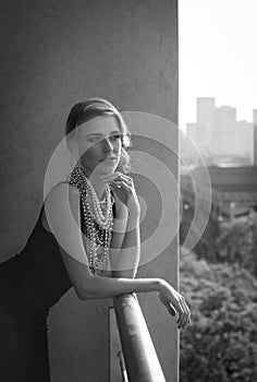 Black and white portrait of woman on urban balcony with view