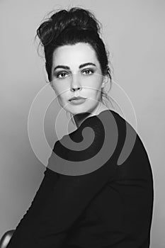 Black and white portrait of young beautiful woman with fancy hair bun
