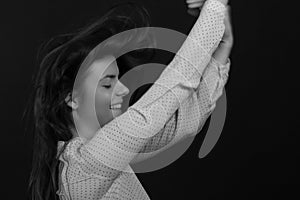 Black and white portrait of a young brunette woman in a studio on a black background