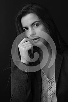 Black and white portrait of a young brunette woman in a studio on a black background