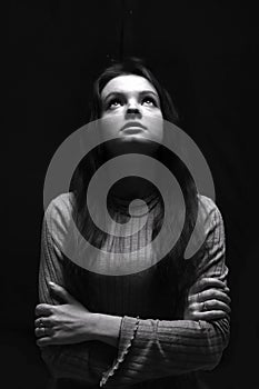 Black and white portrait of a young girl looking up girl with long hair.  Woman prying photo