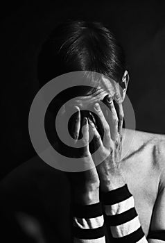 Black and white portrait of young man crying covering the face