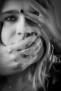 Black and white portrait of a young woman with her face covered with hands, concept for showing the anxieties and fears of women