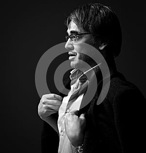 Black and white profile of adult man author, artist in white shirt and teed jacket on shoulders. Side view