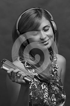 Black and white profile of a young beautiful girl listening to music on headphones