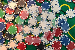 Black white red blue green casino chips stacks on green poker table. Betting club and gamble