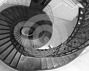Black and white round spiral staircase with black railings with patterns down view