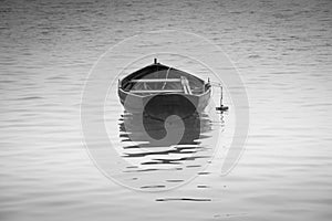 Black and white rowing boat with reflection