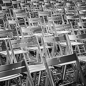 Black and white rows of folding chairs outdoors