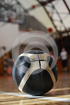 Black and white rubber basketball on the basketball court. Recreation