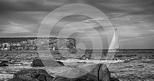 Black and white of sailing boats and cliffs